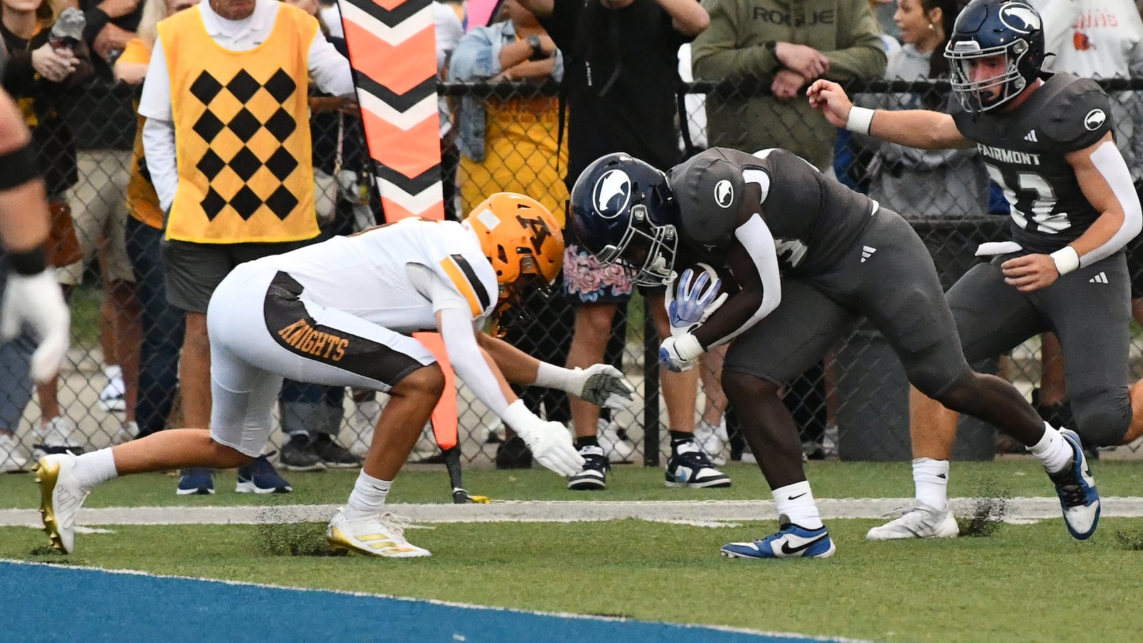 Fairmont's Damien Pattin is about to collide with an Alter defender before scoring a on a nine-yard run in the second quarter to tie the score 7-7 in Thursday night's game at Roush Stadium. JEFF GILBERT/CONTRIBUTED