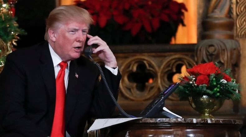 President Donald Trump speaks on the phone with children as they track Santa's movements with the North American Aerospace Defense Command (NORAD) Santa Tracker on Christmas Eve at the president's Mar-a-Lago estate in Palm Beach, Fla., Sunday, Dec. 24, 2017. (AP Photo/Carolyn Kaster)