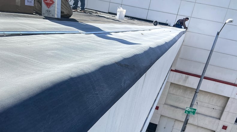 A Maxim Roofing worker repairs the roof of the skywalk between the Dayton Convention Center and the Crowne Plaza Hotel on April 2, 2021 GARLAND COMPANY PHOTO