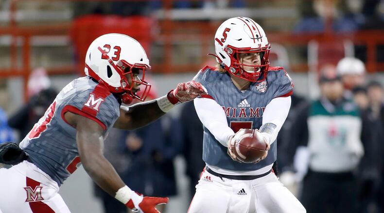 OXFORD, OHIO - NOVEMBER 13: Brett Gabbert #5 hands the ball off to Davion Johnson #23 of the Miami of Ohio Redhawks during the second quarter in the game against the Bowling Green Falcons at Yager Stadium on November 13, 2019 in Oxford, Ohio. (Photo by Justin Casterline/Getty Images)
