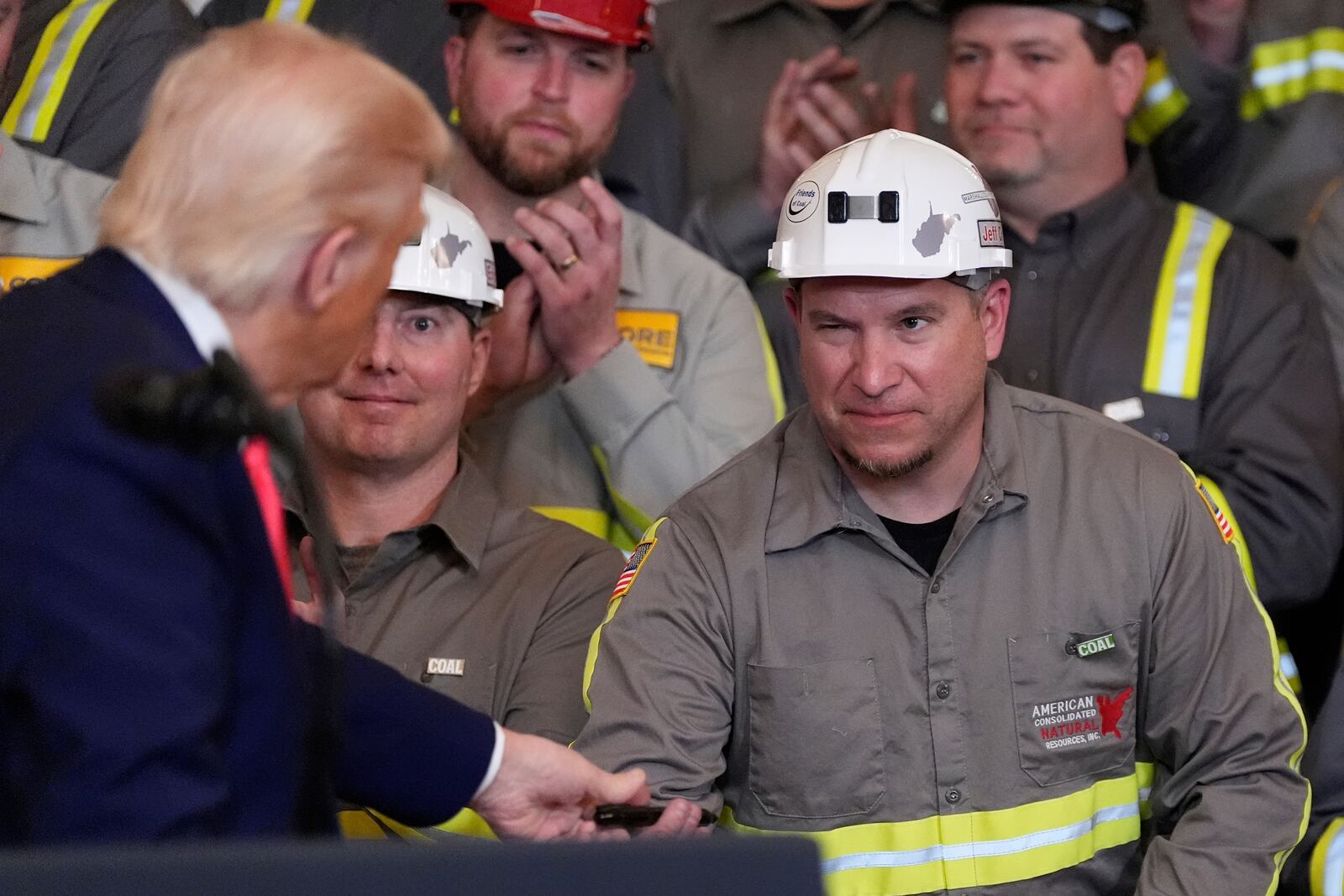 Coal miner Jeff Crowe winks at President Donald Trump after he signed Crowe's speech during an event on energy production in the East Room of the White House, Tuesday, April 8, 2025, in Washington. (AP Photo/Alex Brandon)