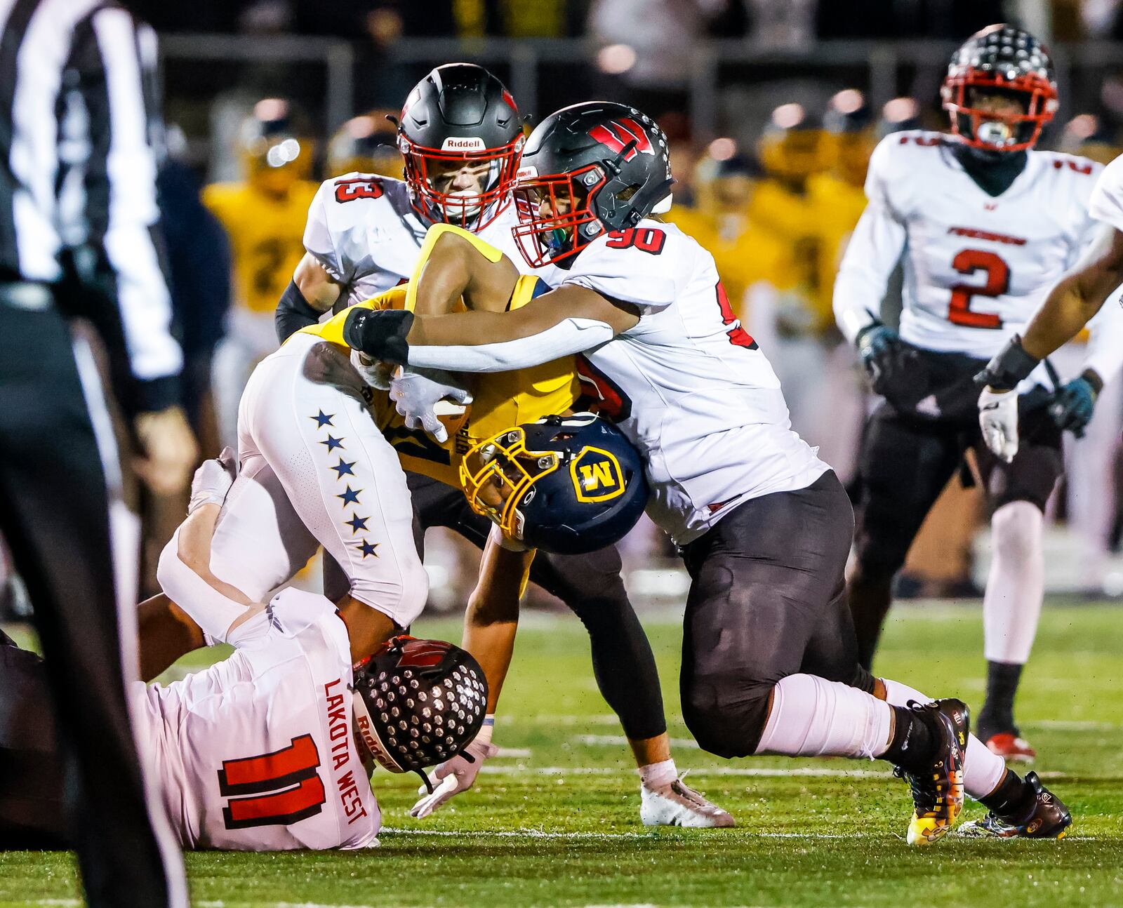 Lakota West defenders Elijah Davis (90) and Jacob Asbeck (11) tackle Moeller running back Jordan Marshall during their Division I Regional final football playoff game Friday, Nov. 19, 2021 at Dwire Field in Mason. Moeller won 21-17. NICK GRAHAM / STAFF
