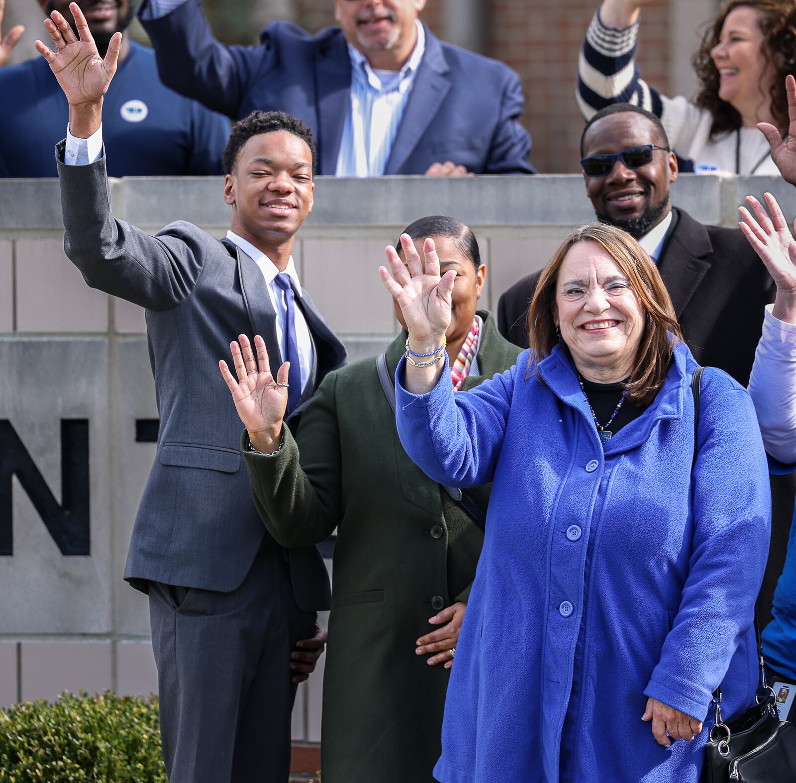 Dalen Myles, bottom left, and Montgomery County Commissioner Carolyn Rice, bottom right, wave during a National Child Abuse Prevention Month event on Wednesday at Haines Children's Center. Myles, a former foster youth, spoke about enduring abuse at home and how an observant adult helped him. Rice also spoke and urged people report suspected abuse. BRYANT BILLING / STAFF