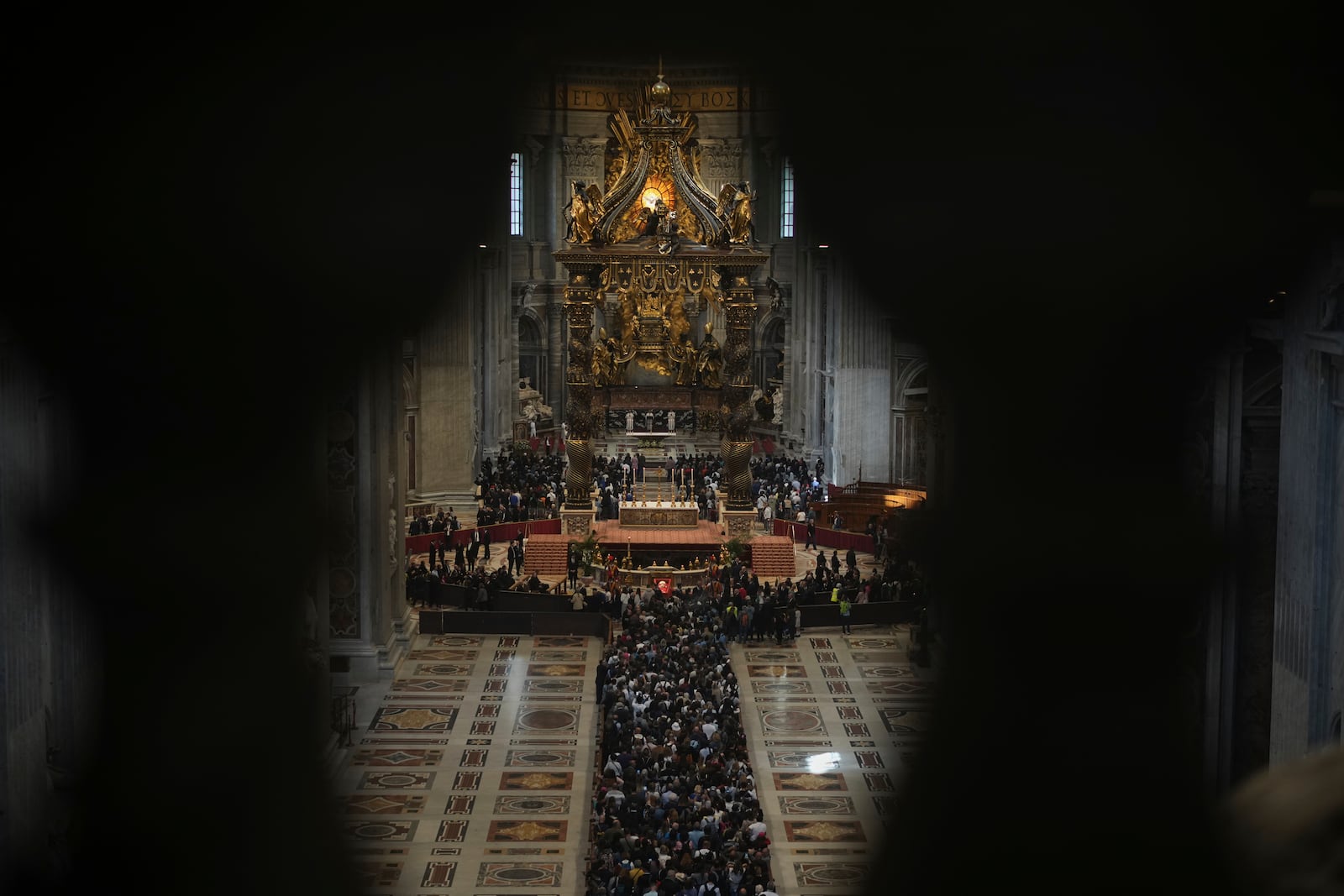 Balcony columns frame the queue of people lining up to pay their respects to Pope Francis lying in state, inside St. Peter's Basilica, at the Vatican, Friday, April 25, 2025. (AP Photo/Andrew Medichini)