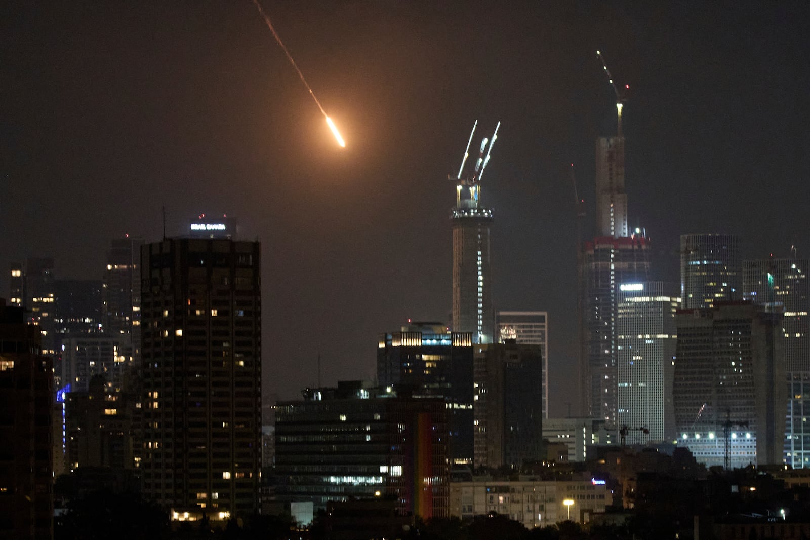 The trace of a projectile is seen before hitting Tel Aviv, Israel, early Saturday, June 14, 2025. (AP Photo/Leo Correa)