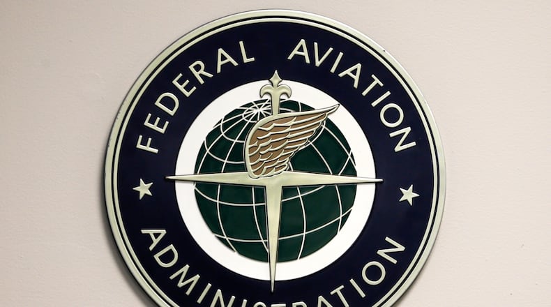 FILE - A Federal Aviation Administration sign hangs in the tower at John F. Kennedy International Airport in New York, March 16, 2017. (AP Photo/Seth Wenig, File)