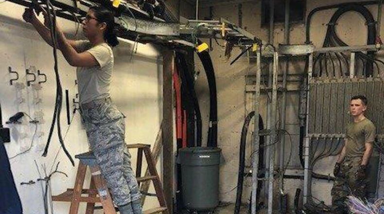 Staff Sgt. Jordan Watson and Airman 1st Class Sindi Viviano remove the old Intermediate Distribution Frame, out of the Bldg. 180 facility, which will be scheduled to be demolished. (U.S. Air Force courtesy photo)
