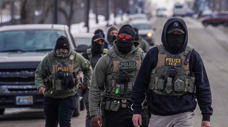 FILE - Federal agents walk down a street while conducting immigration enforcement operations, Thursday, Feb. 5, 2026, in Minneapolis. (AP Photo/Ryan Murphy, File)