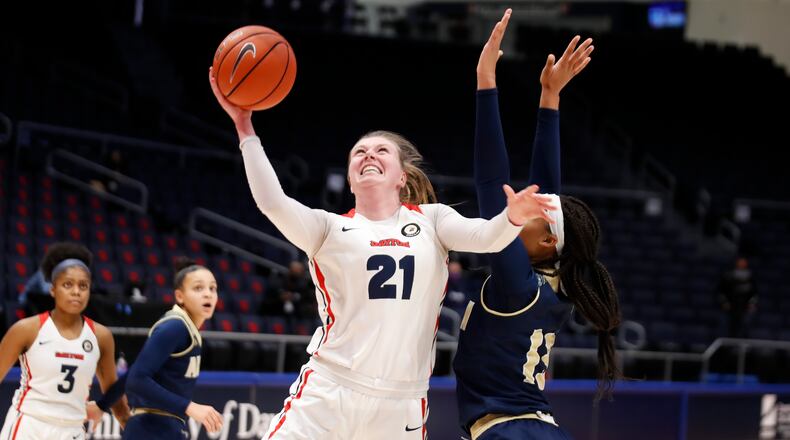 CUTLINE: The University of Dayton's Erin Whalen drives past Akron's Lonasia Brewer during their game on Sunday afternoon at UD Arena. The Zips won 77-74. Michael Cooper/CONTRIBUTED