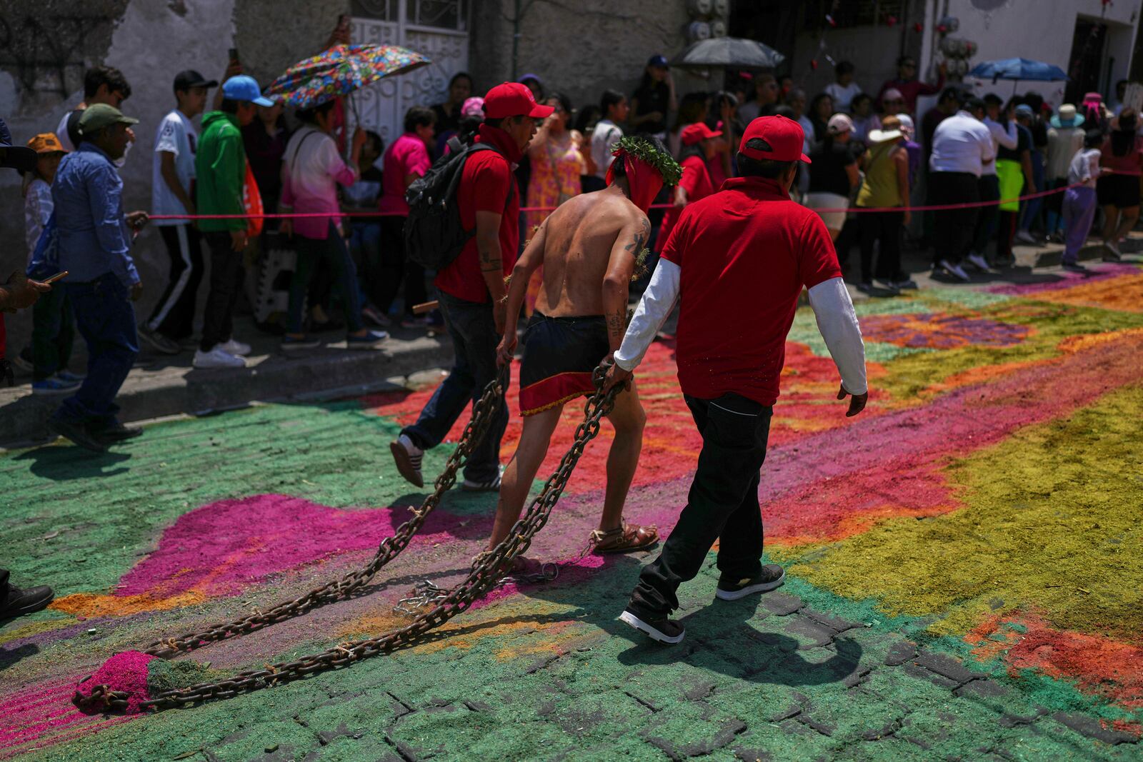 A masked penitent with cacti attached to his arms, drags a chain in a Holy Week procession in Atlixco, Mexico, on Good Friday, April 18, 2025. (AP Photo/Eduardo Verdugo)