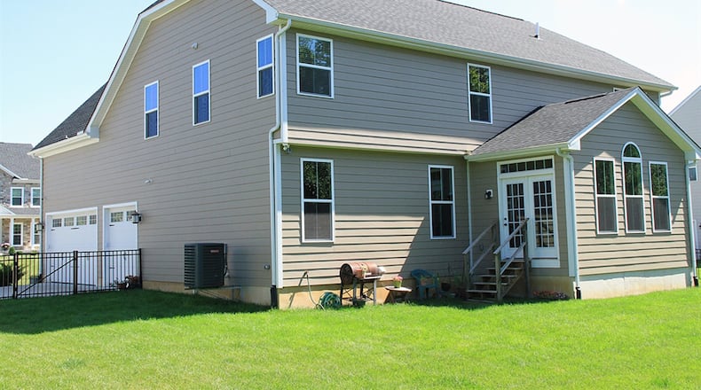 A gabled rooftop above the extended morning room allows for a cathedral ceiling and tall windows topped by a half-moon. Aluminum fencing, one of this home’s upgrades, surrounds the back yard, which is edged by a thick tree line.