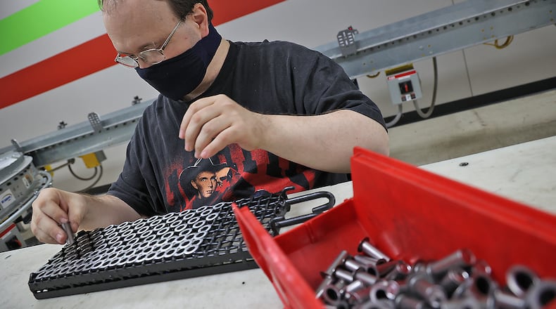 Brian Golem places parts in a cage for TAC Industries in this 2021 photo. FILE