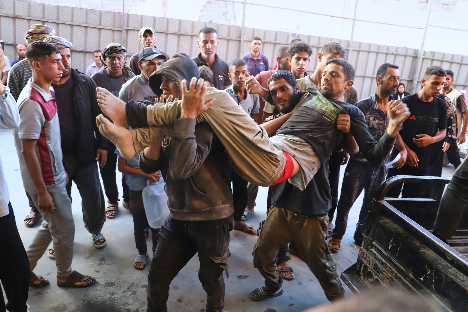 A Palestinian man who was injured during a food distribution at a center run by the Gaza Humanitarian Foundation, a U.S.-backed organization approved by Israel, is carried into Nasser Hospital in Khan Younis, southern Gaza Strip, Saturday, July 19, 2025. (AP Photo/Mariam Dagga)
