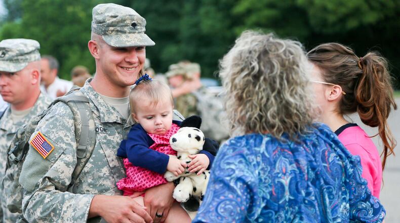 Josh Moore greets his daughter Adaline, 15 months, his wife Katherine, and other family members after returning from deployment, Thursday, Aug. 4, 2016. More than 100 members of the Middletown-based Ohio Army National Guard's 324th Military Police Co. returned to a Welcoming Ceremony at Franklin High School after an 11-month deployment guarding prisoners at Guantanamo Bay, Cuba. GREG LYNCH / STAFF