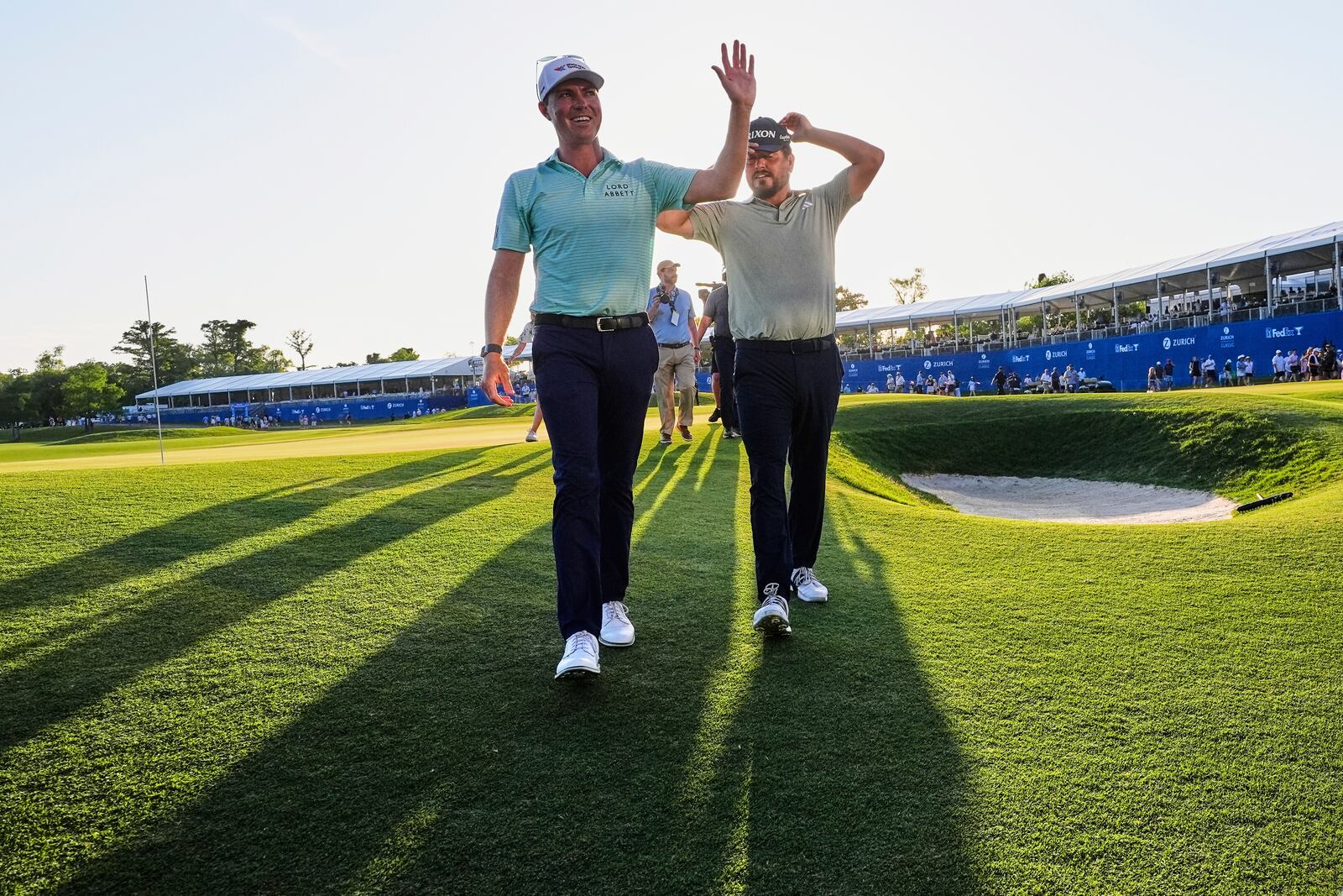 Ben Griffin, left, walks off the 18th green with teammate Andrew Novak, after they won the PGA Zurich Classic golf tournament at TPC Louisiana in Avondale, La., Sunday, April 27, 2025. (AP Photo/Gerald Herbert)