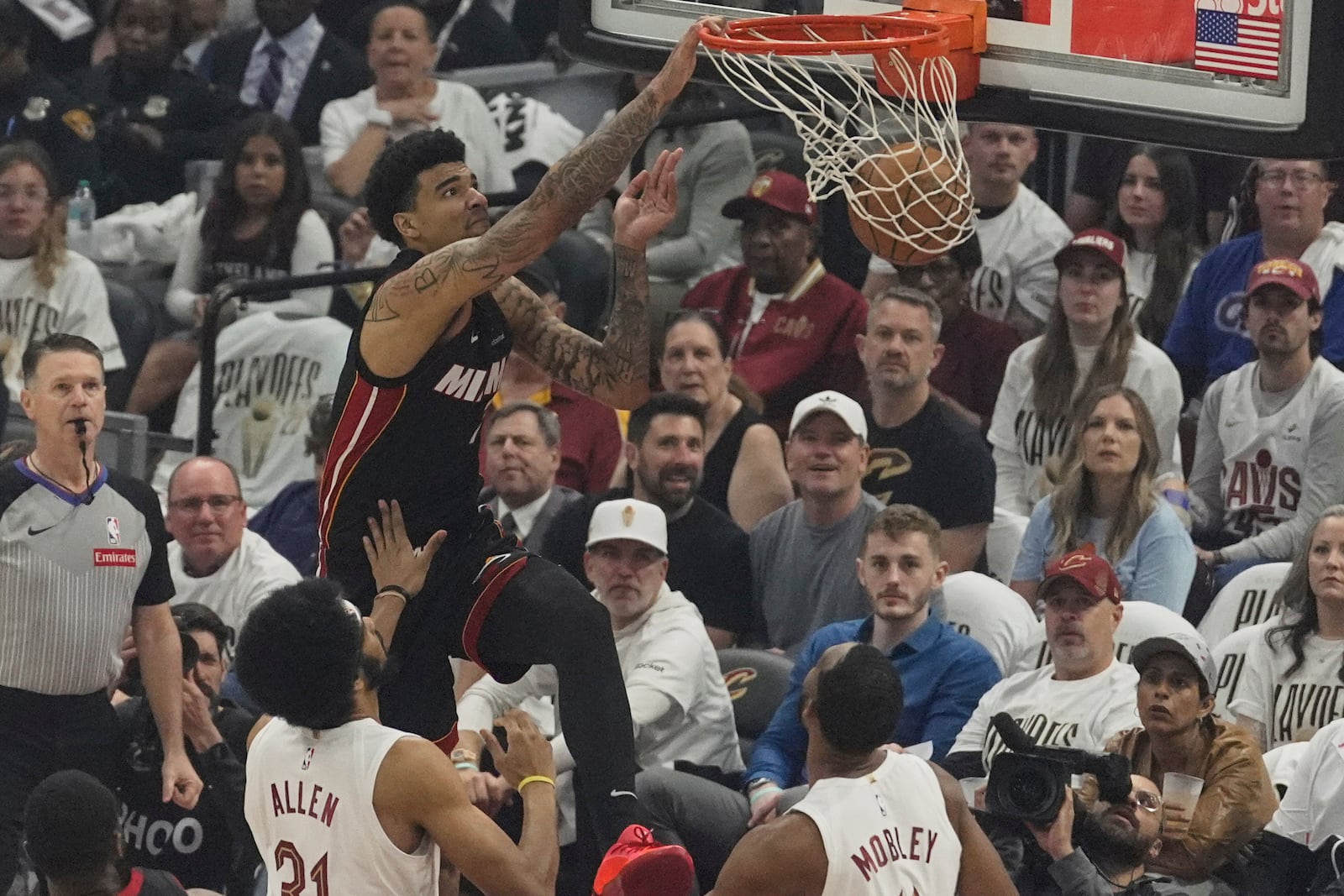 Miami Heat center Kel'el Ware, left, dunks over Cleveland Cavaliers center Jarrett Allen (31) and forward Evan Mobley, right, in the first half in Game 2 of an NBA first-round playoff series, Wednesday, April 23, 2025, in Cleveland. (AP Photo/Sue Ogrocki)