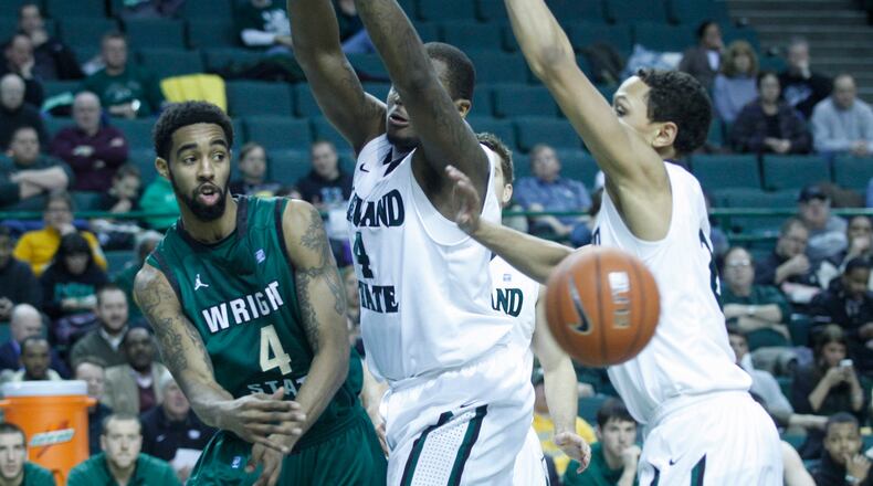 Wright State’s Jerran Young passes around Cleveland State’s Devon Long and Bryn Forbes on Wednesday in Cleveland. Photo by David Jablonski