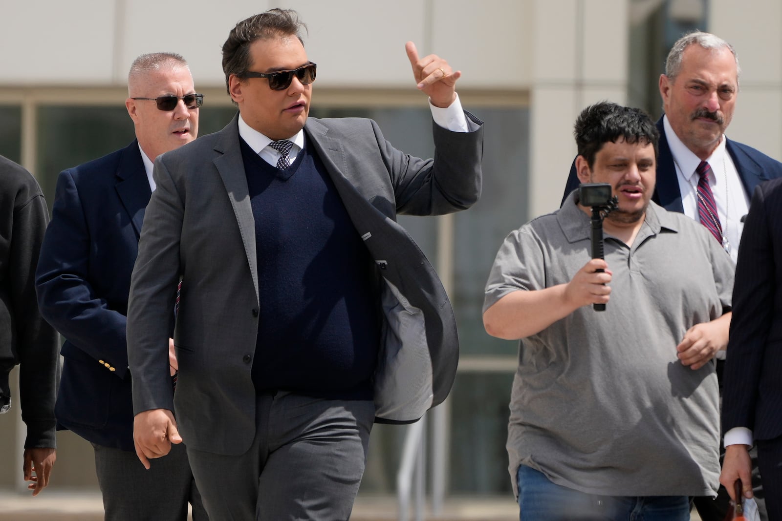 Former U.S. Rep. George Santos, left, leaves federal court after being sentenced to more than seven years in prison for fraud and identity theft, Friday, April 25, 2025, in Central Islip, N.Y. (AP Photo/Julia Demaree Nikhinson)