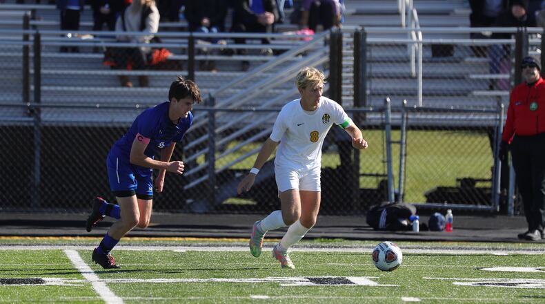 Centerville senior Caleb McComas (right) possesses the ball against St. Xavier during Saturday's Division I regional final. CONTRIBUTED