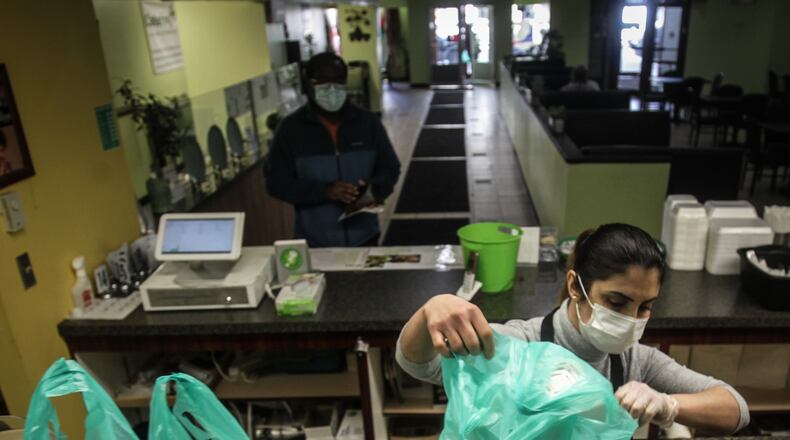 Olive Mediterranean Grill cook, Rana Abbasova readies carryout at the restaurant on Friday March 12, 2021. When the last similar payments came in the previous stimulus package, over half of Ohioans in the survey said that they used at least some of their payment for food, from groceries to eating out, JIM NOELKER/STAFF PHOTO