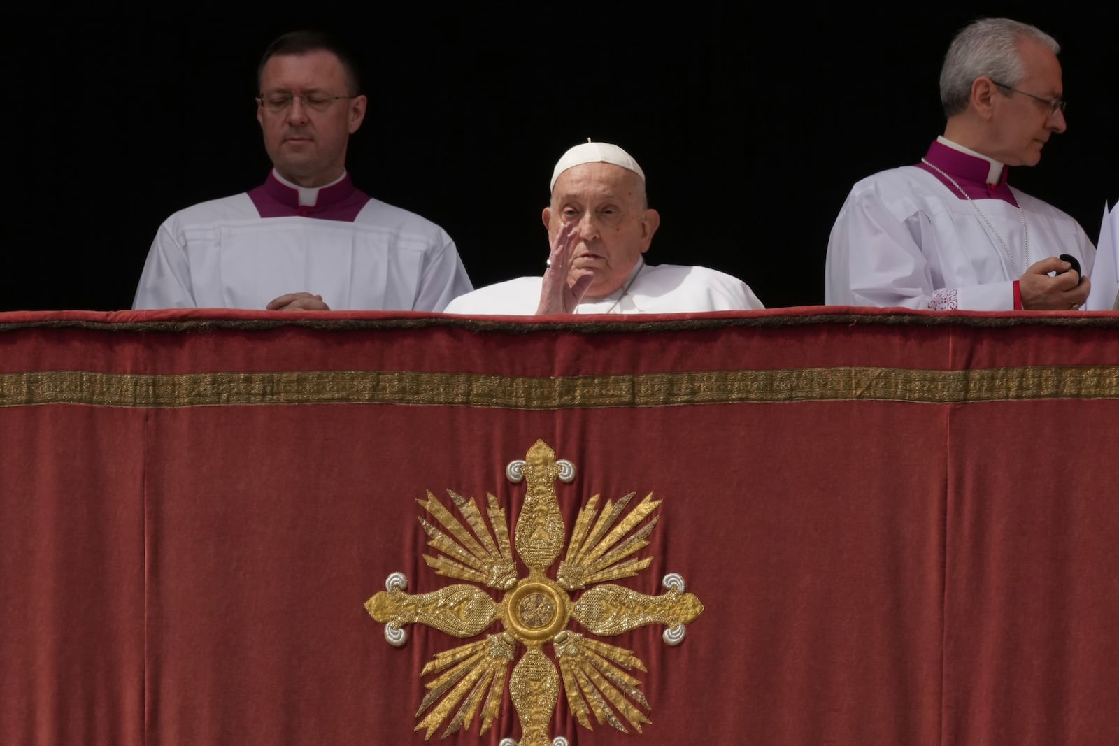 Pope Francis bestows the Urbi et Orbi (Latin for to the city and to the world) blessing from the central lodge of St. Peter's Basilica at the end of the Easter mass presided over by Cardinal Angelo Comastri in St. Peter's Square at the Vatican Sunday, April 20, 2025. (AP Photo/Andrew Medichini)