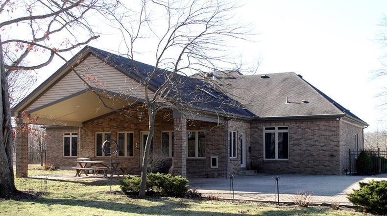 A cathedral ceiling peaks over the sun room of this brick ranch home.