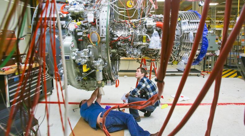 Engineers work on a LEAP commercial jet test engine at GE Aviation in Evendale in this Dec. 19, 2014 photo. The engine, made by CFM, a joint venture between GE and French manufacturer Snecma, will be more fuel efficient and will contain advanced materials, into which GE Aviation has increasingly invested. GREG LYNCH/STAFF