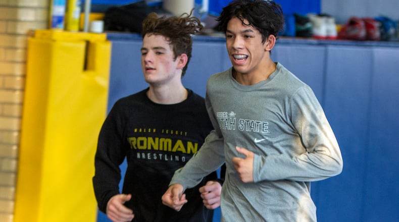Legacy Christian junior Dillon Campbell, right, runs laps in the team's wrestling room Monday alongside freshman Nathan Attisano. Both are competing in the Division III state wrestling tournament this weekend, and Campbell is going for his third straight state title. CONTRIBUTED/Jeff Gilbert