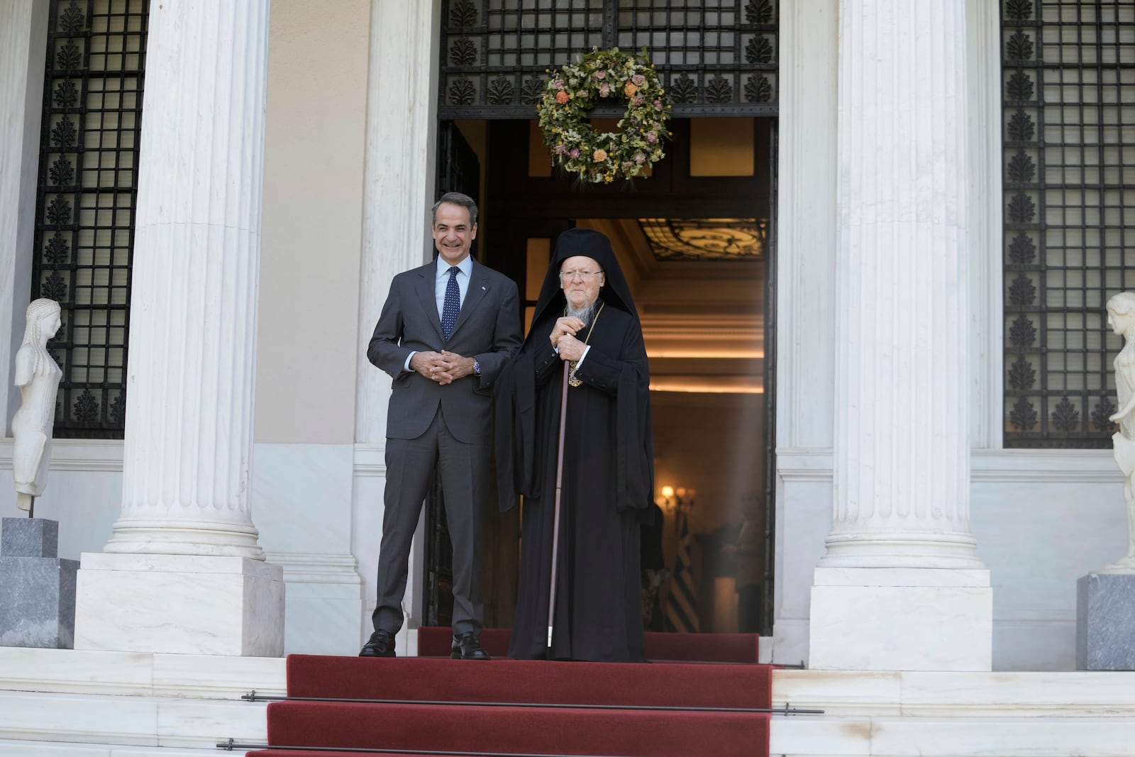 Greece's Prime Minister Kyriakos Mitsotakis, left, and the Orthodox Ecumenical Patriarch Bartholomew pose for photographers before their meeting in Athens, on Thursday May 8, 2025. (AP Photo/Petros Giannakouris)