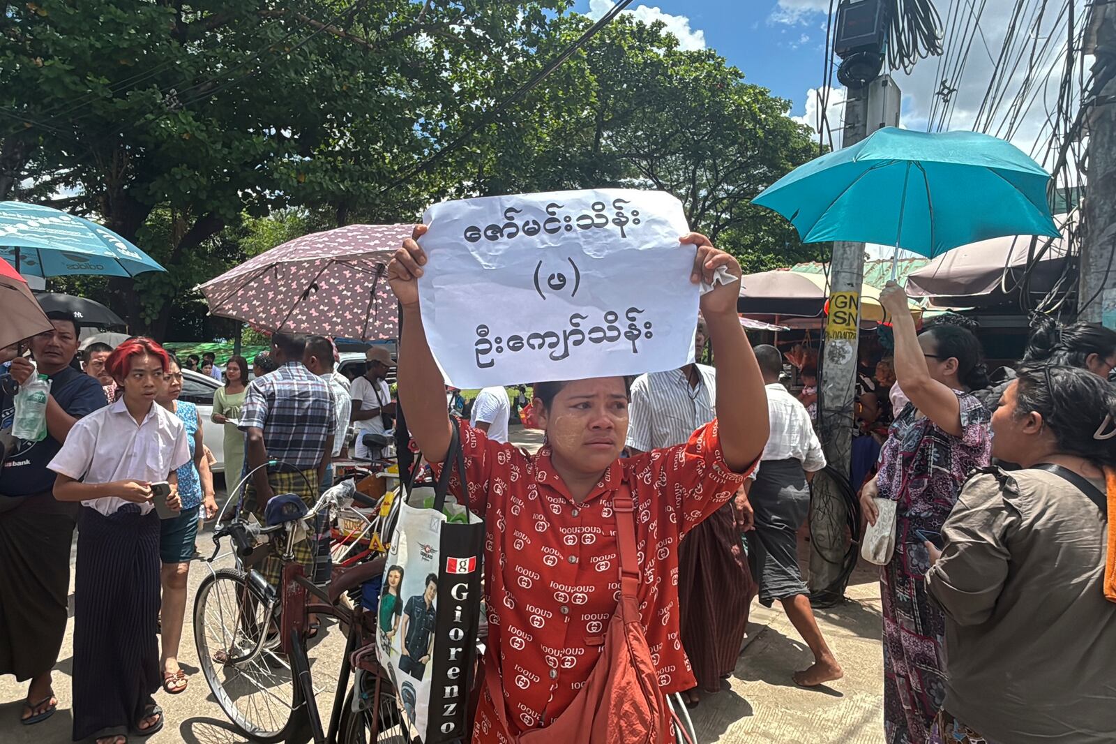 A person holds a sign of name as family members and colleagues wait to welcome released prisoners outside the main gate of Insein prison Thursday, April 17, 2025, in Yangon, Myanmar. (AP Photo/Thein Zaw)