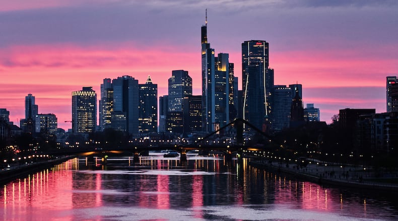 The sun has set behind the buildings of the banking district in Frankfurt, Germany, late Tuesday, March 24, 2026. (AP Photo/Michael Probst)