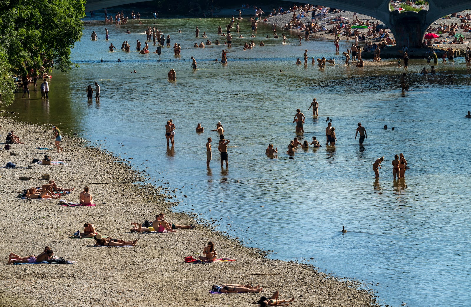 People enjoy the waters of the Isar around the Kabelsteg in Munich, Germany, Sunday June 29, 2025. (Peter Kneffel/dpa via AP)