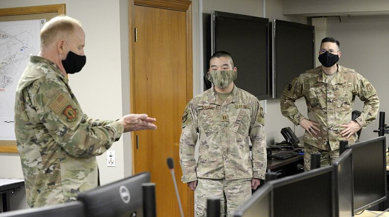 Lt. Gen. Robert D. McMurry Jr. (left), Air Force Life Cycle Management Center commander, presents an AFLCMC challenge coin to Capt. Joseph Suwabe, 88th Air Base Wing Incident Command Center financial chief at Wright-Patterson Air Force Base. (U.S. Air Force photo/Ty Greenlees)