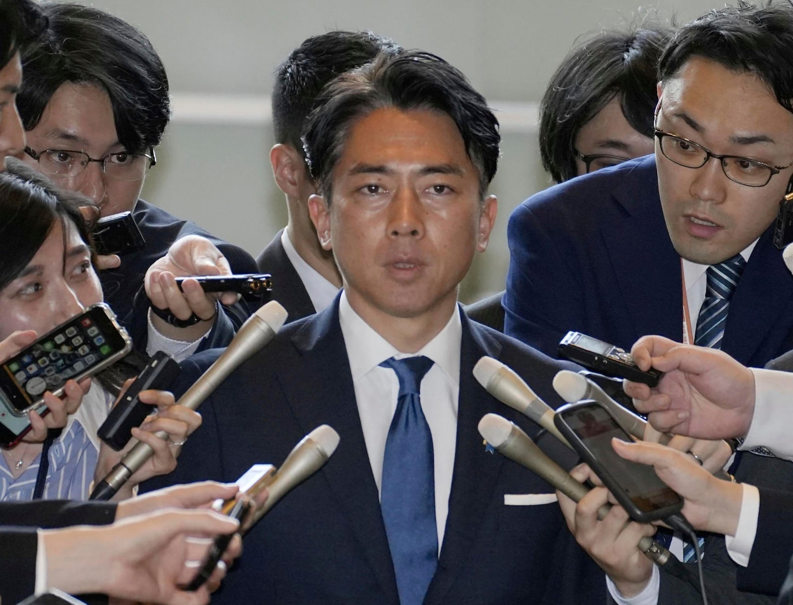 Former Environment Minister Shinjiro Koizumi, center, is surrounded by reporters at the prime minister's office in Tokyo Wednesday, May 21, 2025. (Kyodo News via AP)