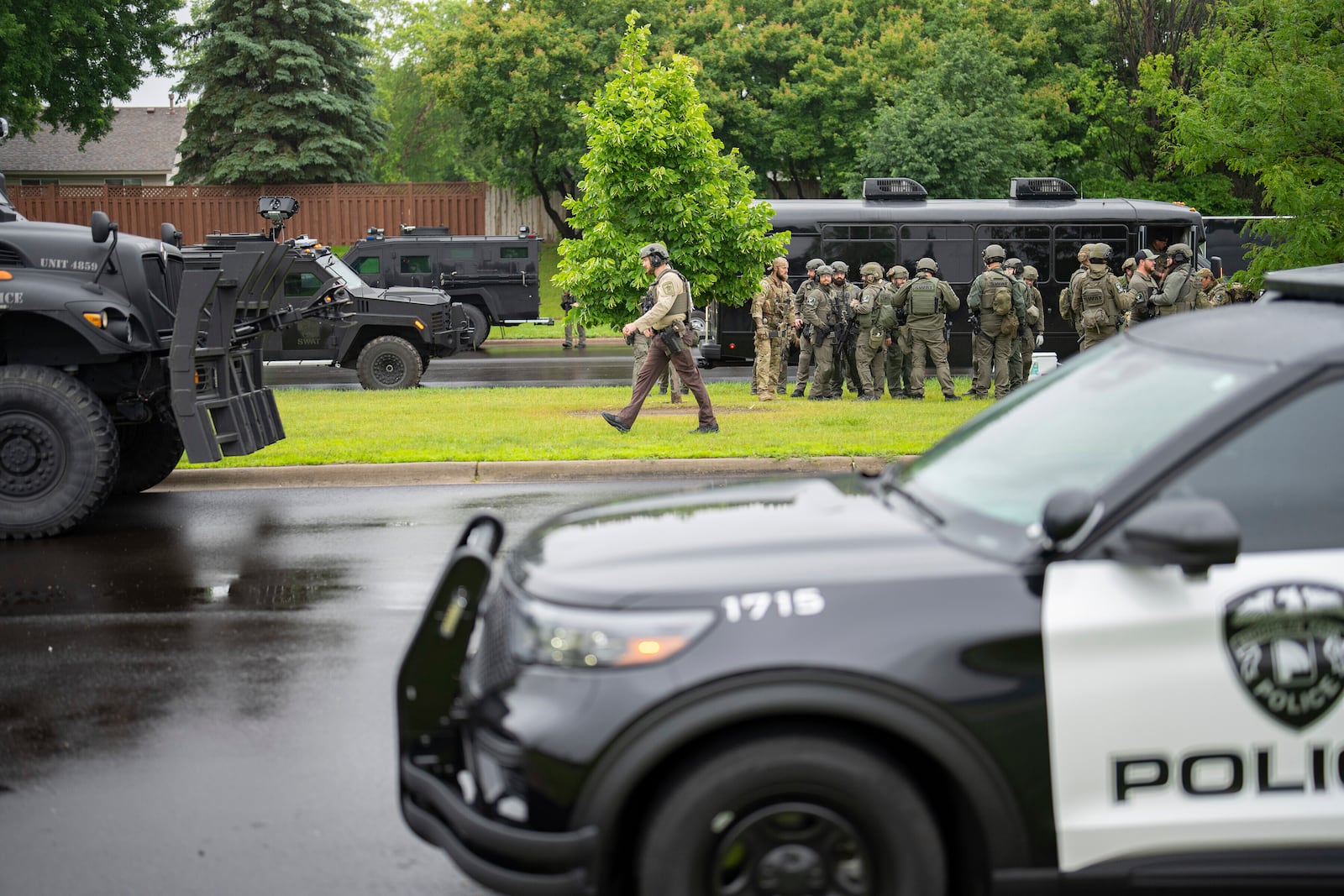 Law enforcement officers including local police, sheriffs and the FBI, stage less than a mile from a shooting in Brooklyn Park, Minn. on Saturday, June 14, 2025. (Alex Kormann/Star Tribune via AP)