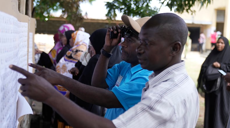Voters verify their names before voting during the general elections at Mpendaye polling station in Zanzibar, Tanzania, Wednesday, Oct. 29, 2025. (AP Photo/Brian Inganga)