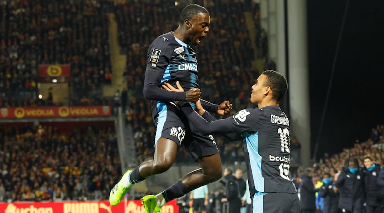 Marseille's Mason Greenwood, right, celebrates with Marseille's Timothy Weah after scoring his sides first goal during the French League One soccer match between Lens and Marseille in Lens, France, Saturday, Oct. 25, 2025. (AP Photo/Jean-Francois Badias)