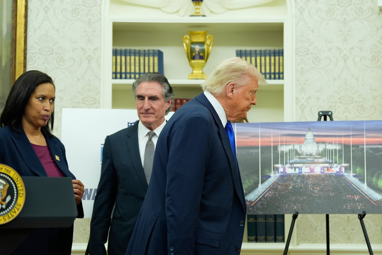 President Donald Trump, from right, departs as Interior Secretary Doug Burgum and District of Columbia Mayor Muriel Bowser look on after an event to announce that the 2027 NFL Draft will be held on the National Mall, in the Oval Office of the White House, Monday, May 5, 2025, in Washington. (AP Photo/Alex Brandon)
