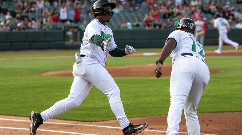Dayton third baseman Cam Collier rounds first base with the first of his two home runs and is congratulated by coach Jefry Sierra on Thursday night at Day Air Ballpark. Jeff Gilbert/CONTRIBUTED