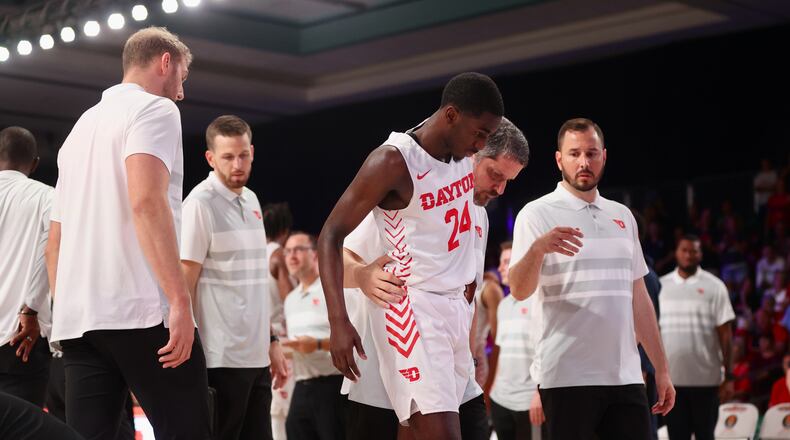 Dayton's Kobe Elvis is helped to the locker room by trainer Mike Mulcahey after an injury in the second half during a game against BYU in the Battle 4 Atlantis on Friday, Nov. 25, in Nassau, Bahamas. David Jablonski/Staff