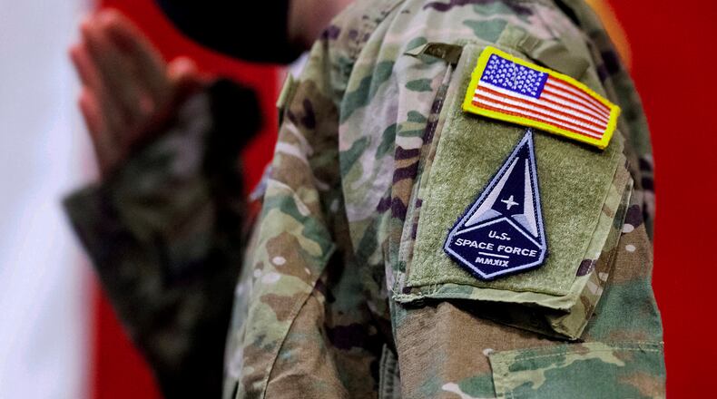 FILE - An Air Force specialist salutes in a U.S. Space Force uniform during a ceremony for U.S. Air Force airmen transitioning to U.S. Space Force guardian designations Feb. 12, 2021, at Travis Air Force Base, Calif. About 1,000 Air National Guard troops who are assigned to space missions are mired in an identity crisis. According to commanders, the troops' units are torn between the Air Force, where they've historically been assigned, and the military's shiny new Space Force, where they now work. (Noah Berger/San Francisco Chronicle via AP, File)