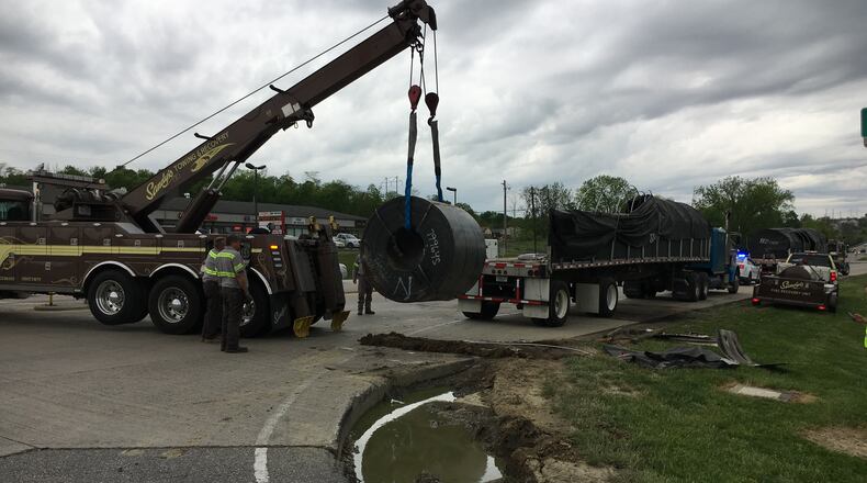 Crews from Sandy’s Towing lift a steel coil weighing more than 58,000 pounds onto a semi-trailer Friday afternoon at American Way and Ohio 63 in Monroe. The semi-trailer that was carrying the steel coil overturned on Ohio 63, dropping the coil on the shoulder. The accident resulted in closing the westbound lanes of Ohio 63 for more than two and a half hours. ED RICHTER/STAFF
