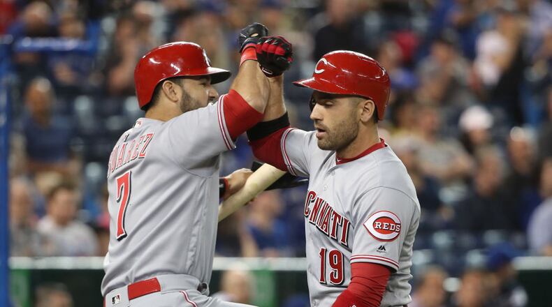 TORONTO, ON - MAY 30: Joey Votto #19 of the Cincinnati Reds is congratulated by Eugenio Suarez #7 after hitting a solo home run in the first inning during MLB game action against the Toronto Blue Jays at Rogers Centre on May 30, 2017 in Toronto, Canada. (Photo by Tom Szczerbowski/Getty Images)