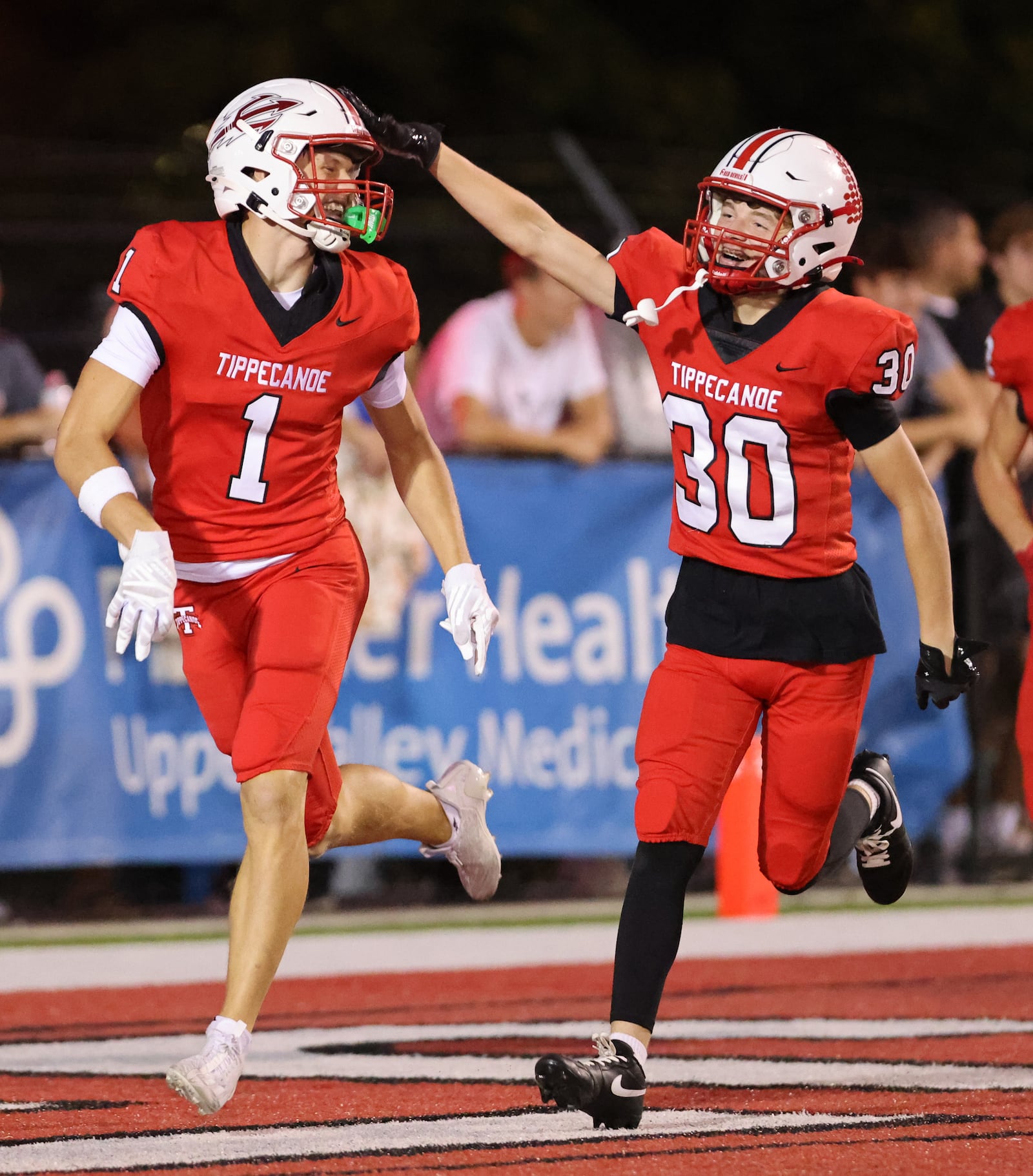 Tippecanoe's Bentley Heckman congratulates senior receiver Will Strong after Strong scored on a 57-yard touchdown reception in the fourth quarter of a Miami Valley League game against Sidney on Thursday, Sept. 24 at City Park in Tipp City. BRYANT BILLING / STAFF
