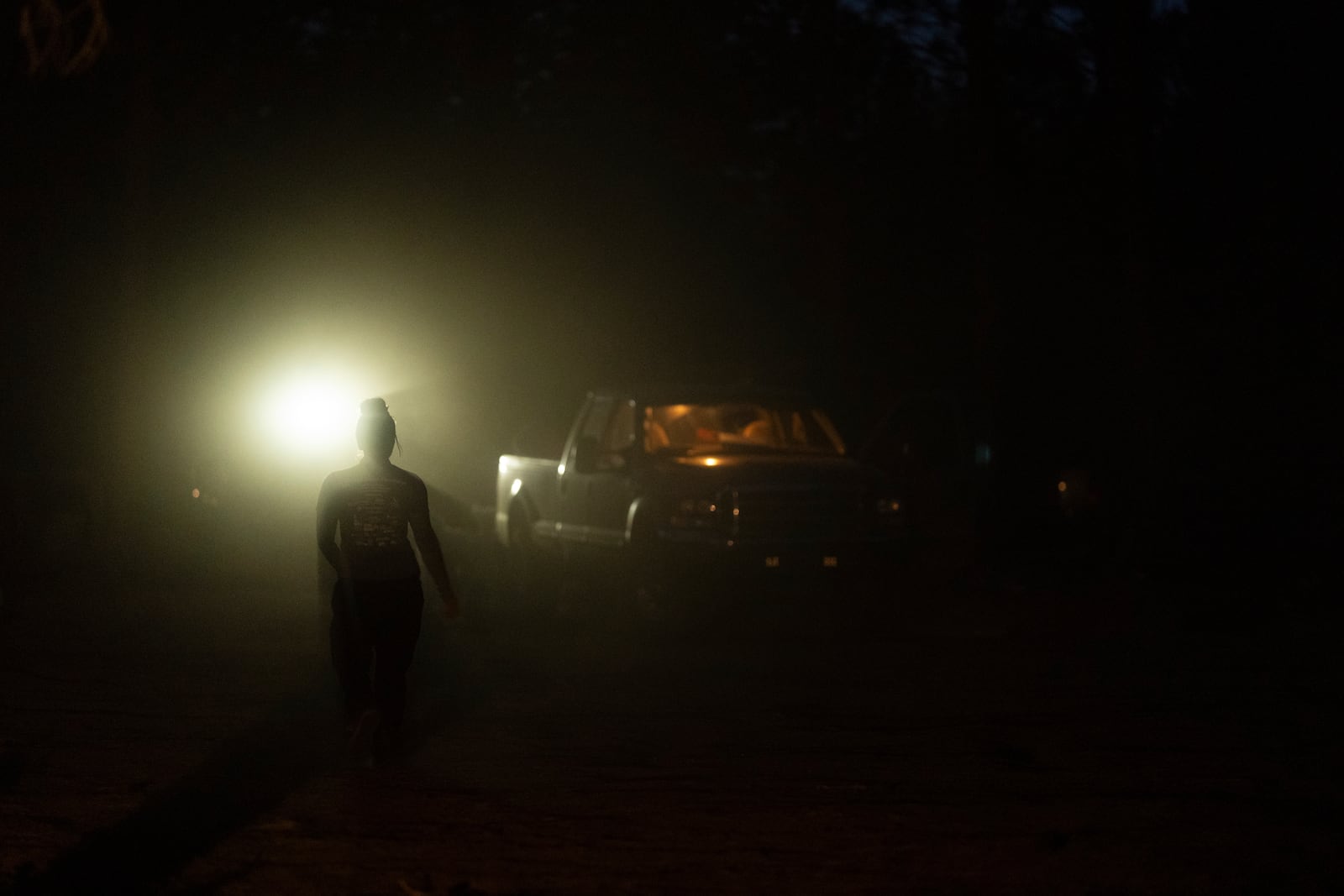 Mandy Bryant walks to help Mike Shelton with his trailer as they load up their belongings at a homeless encampment in Deschutes National Forest, Wednesday, April 30, 2025, near Bend, Ore. (AP Photo/Jenny Kane)