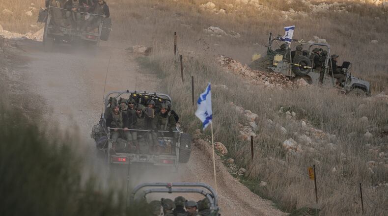 FILE - Israeli soldiers cross the security fence moving towards the so-called Alpha Line that separates the Israeli-annexed Golan Heights from Syria, in the town of Majdal Shams, Dec. 15, 2024. (AP Photo/Matias Delacroix, File)