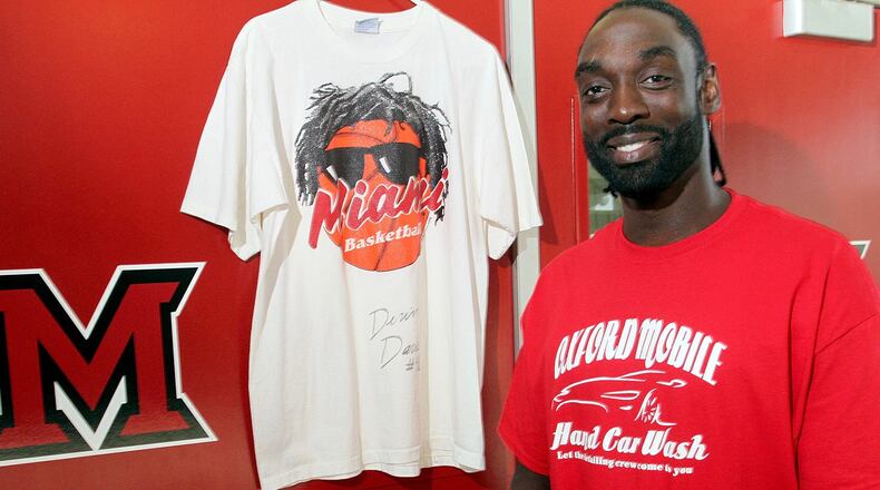 Devin Davis, a Miami University sports hall of fame member, with a shirt from his playing days, center, and wearing one for the local business he has started, at Millett Hall in Oxford Thursday, July 11, 2013.CONTRIBUTED PHOTO BY E.L. HUBBARD
