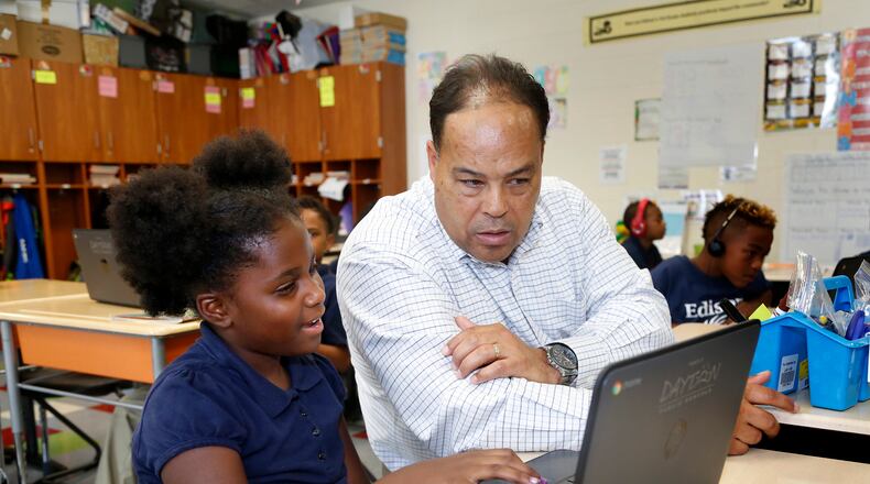 Anthony Taylor, a third-grade teacher at Edison PreK-6 in Dayton, works with A-Robbin Crisp in class last year. LISA POWELL / STAFF