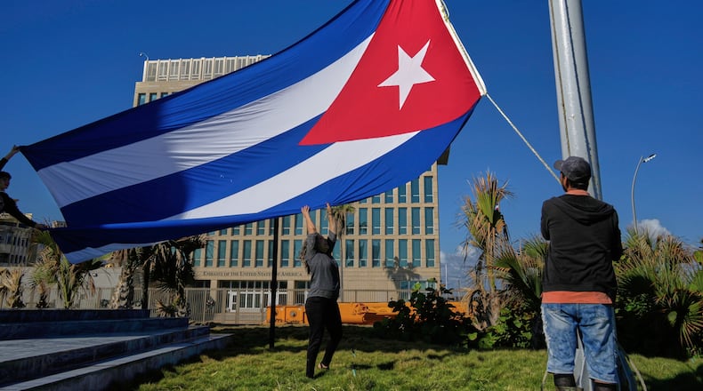 Workers fly the Cuban flag at half-mast at the Anti-Imperialist Tribune near the U.S. embassy in Havana, Cuba, Monday, Jan. 5, 2026, in memory of Cubans who died two days before in Caracas, Venezuela during the capture of Venezuelan President Nicolas Maduro by U.S. forces. (AP Photo/Ramon Espinosa)