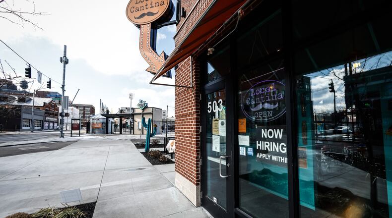 The Local Cantina on Est First St. in Dayton has a help wanted sign on the front door. JIM NOELER/STAFF
